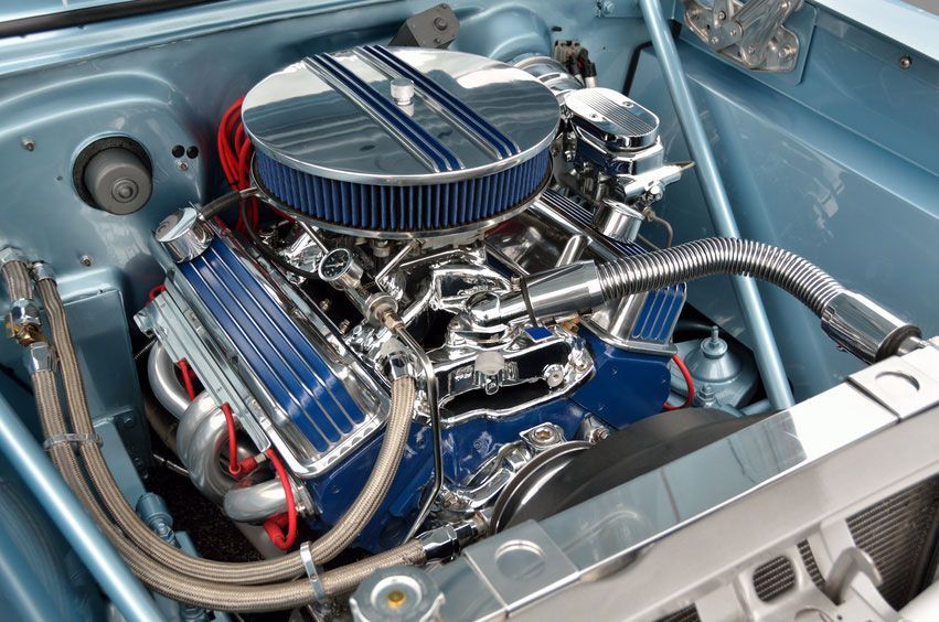 Polished blue V8 engine with chrome parts in a car engine bay