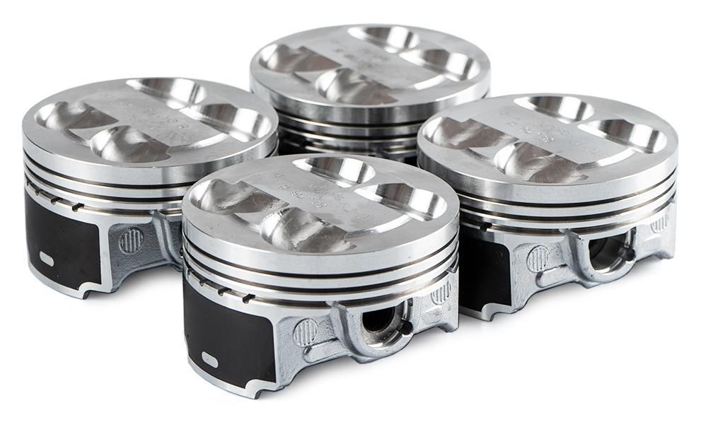 Four shiny metal pistons arranged on a white background