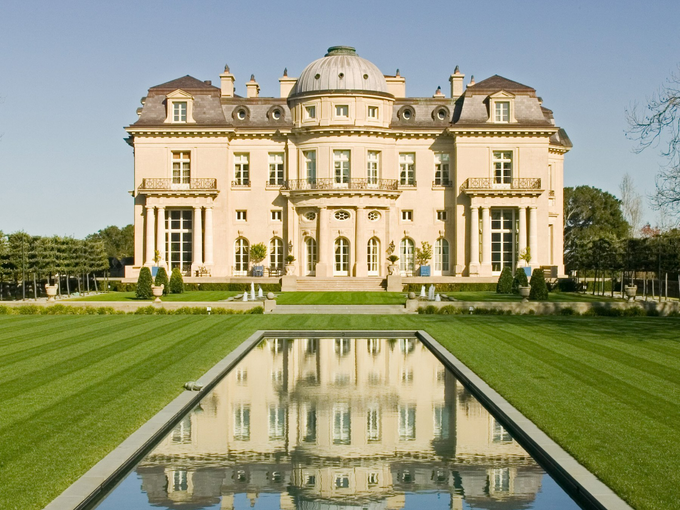 A large house with a pool in front of it