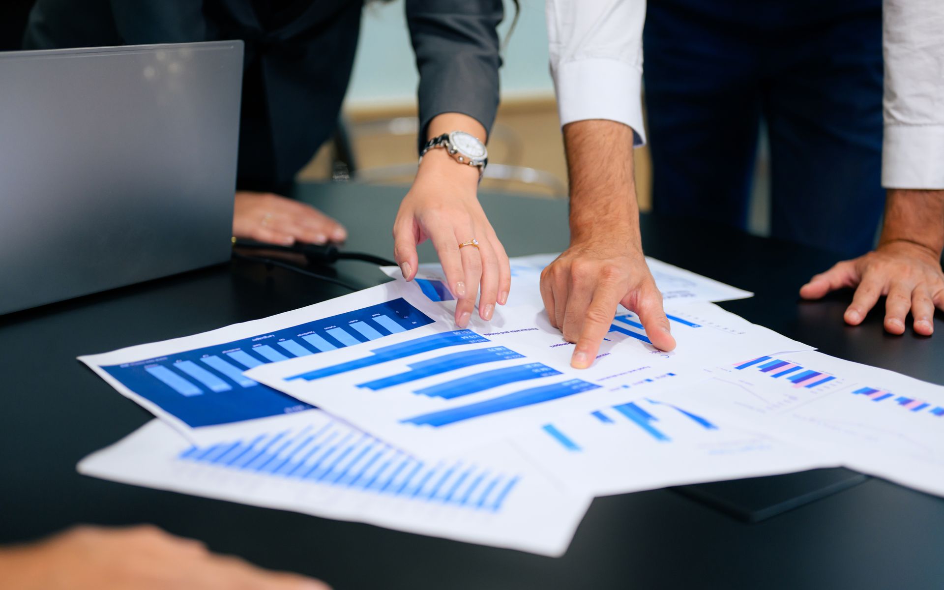 A group of people are looking at a graph on a table.
