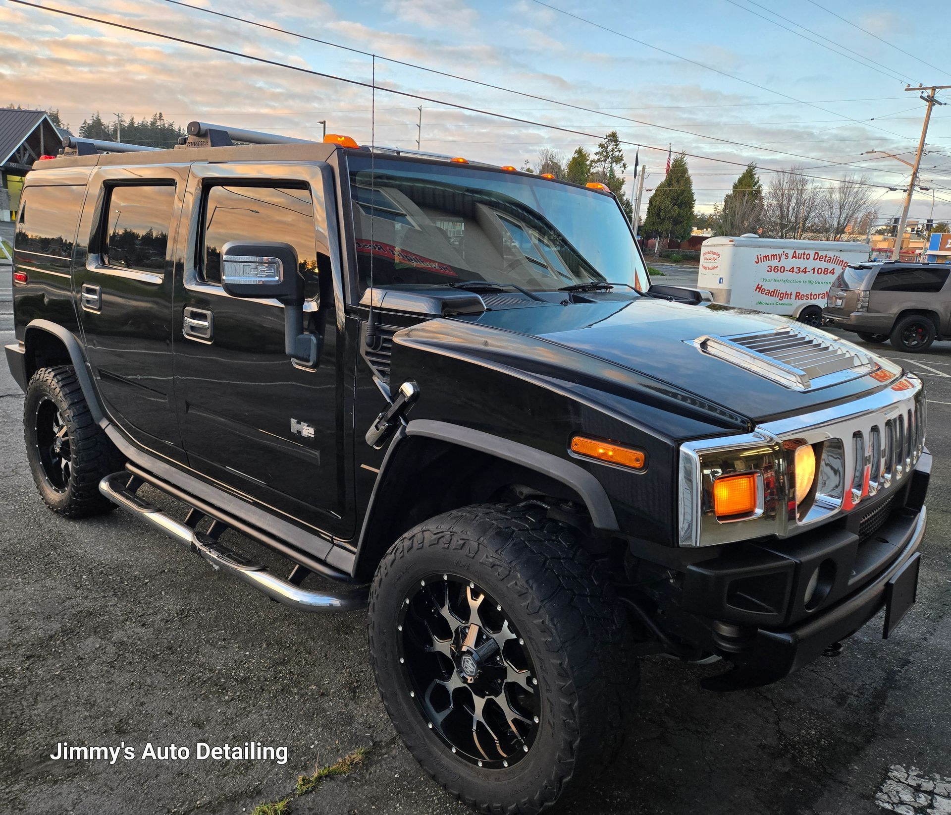 A black hummer is parked in a parking lot