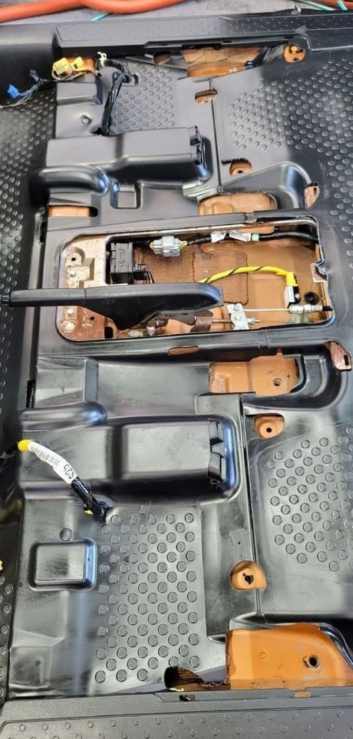A close up of a car seat with a bunch of wires coming out of it.