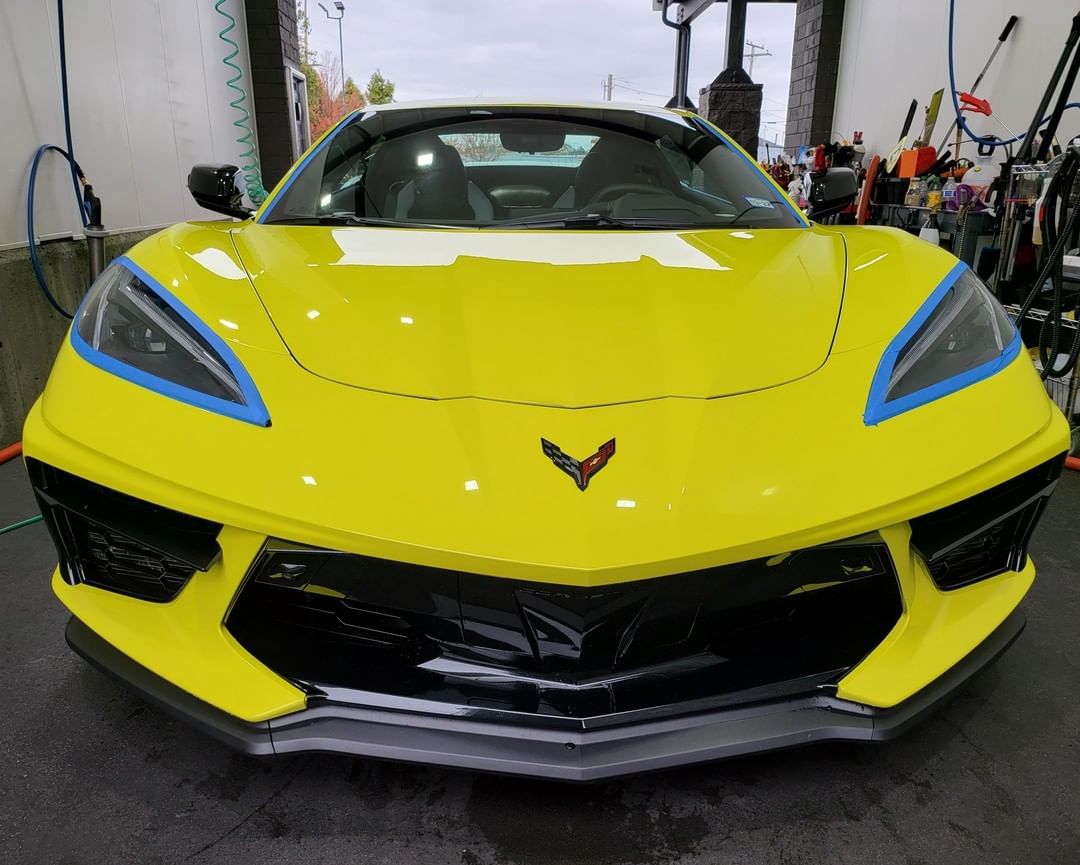 A yellow sports car is parked in a garage.