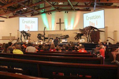 Matt teaching in front of dino skeletons on stage