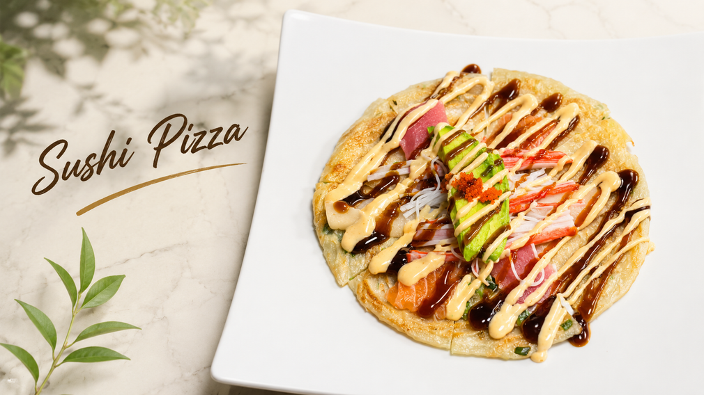 Sushi pizza on a white plate, drizzled with sauce and topped with avocado and crab sticks