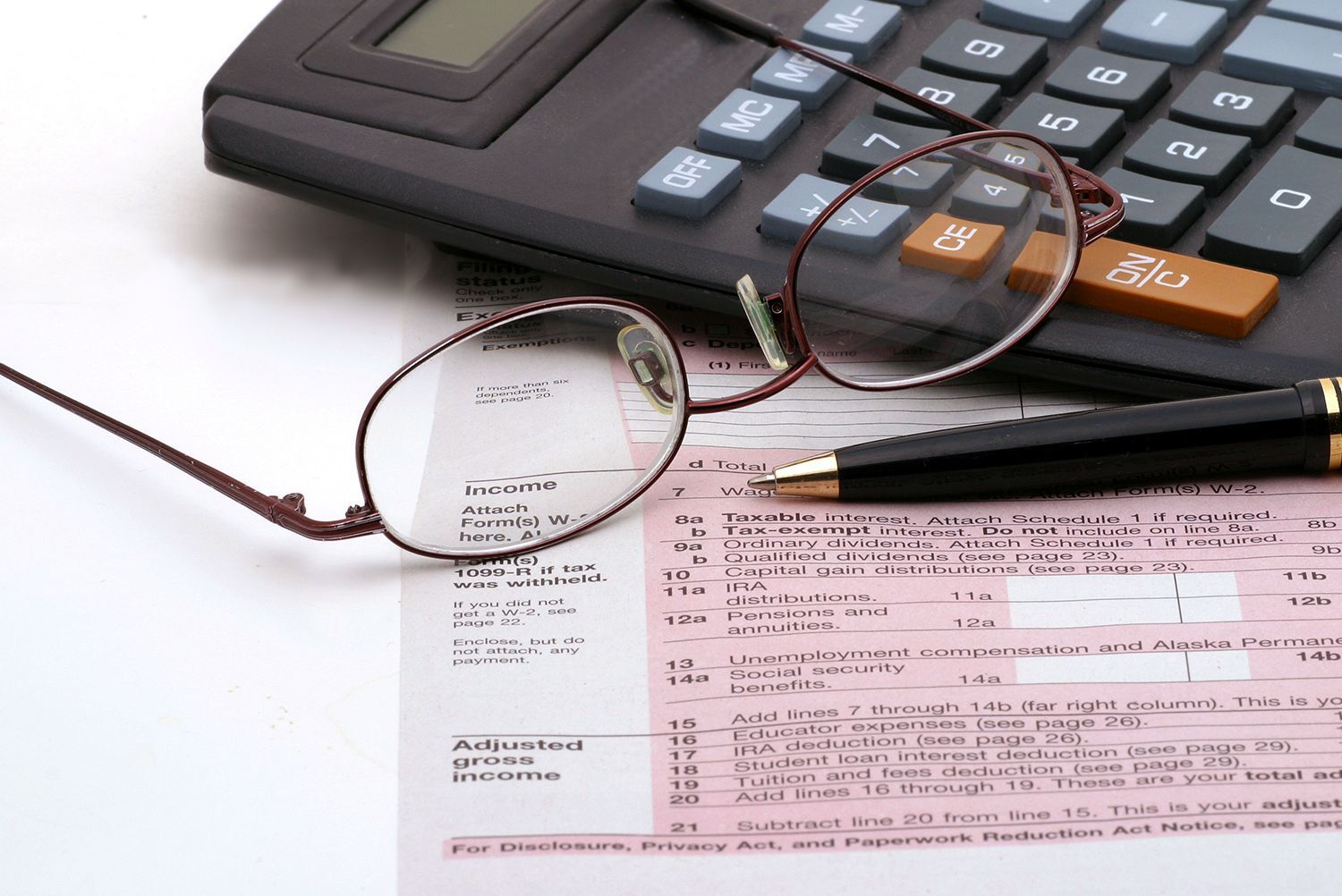 A pair of glasses sitting on top of a calculator