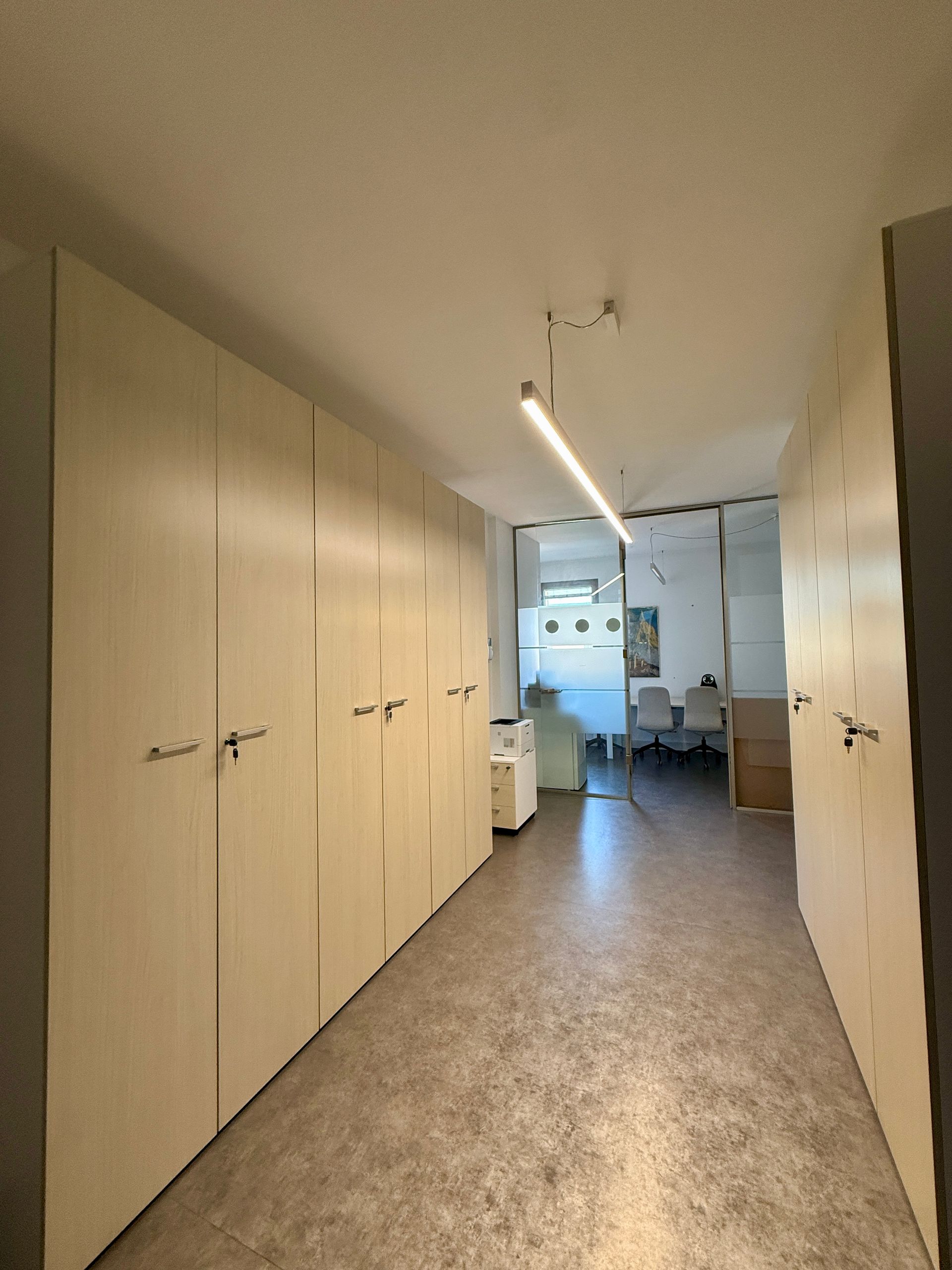 Un corridoio con molti armadi e una luce sul soffitto