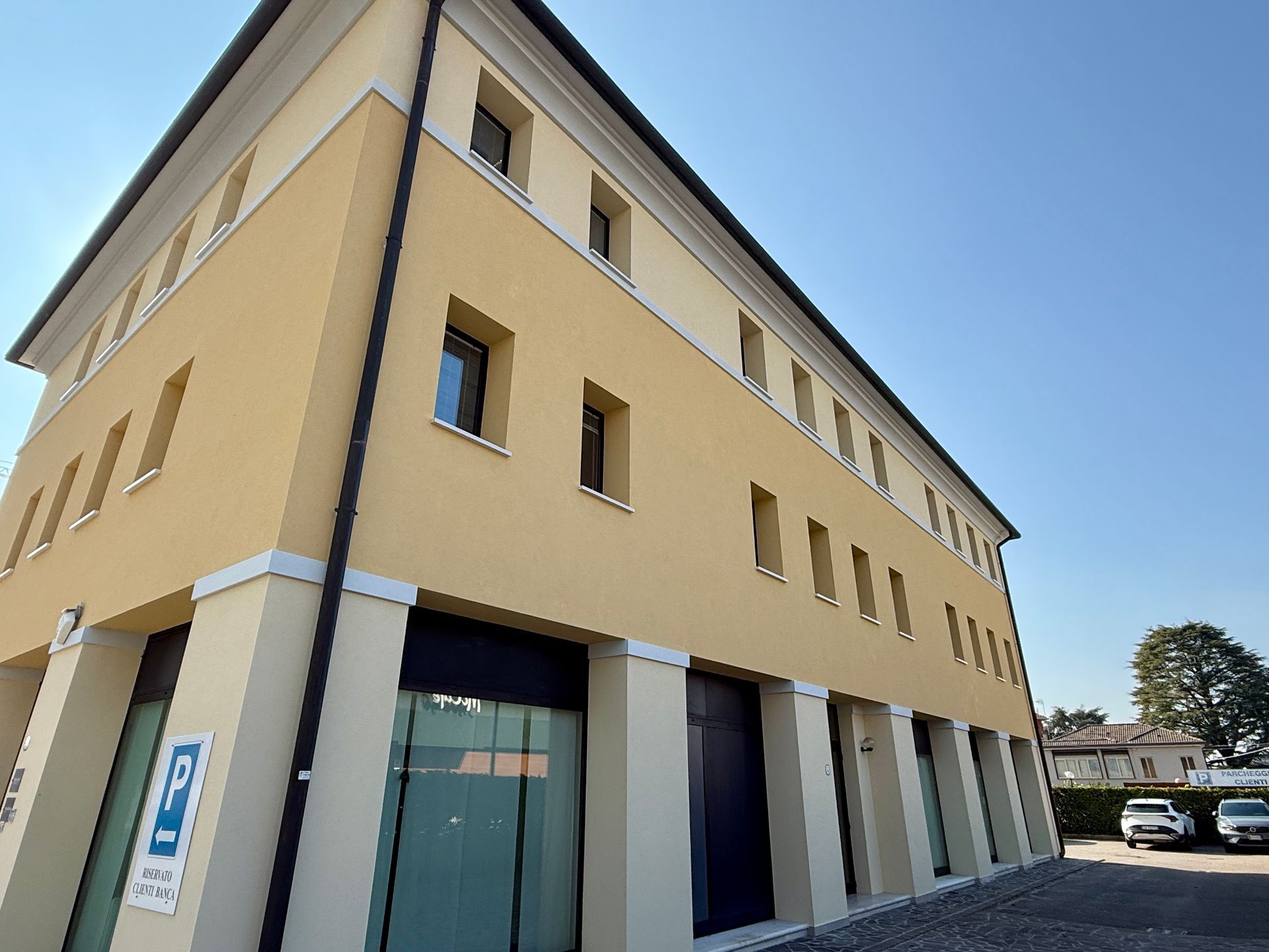 Un grande edificio giallo con un cartello sul lato che dice 