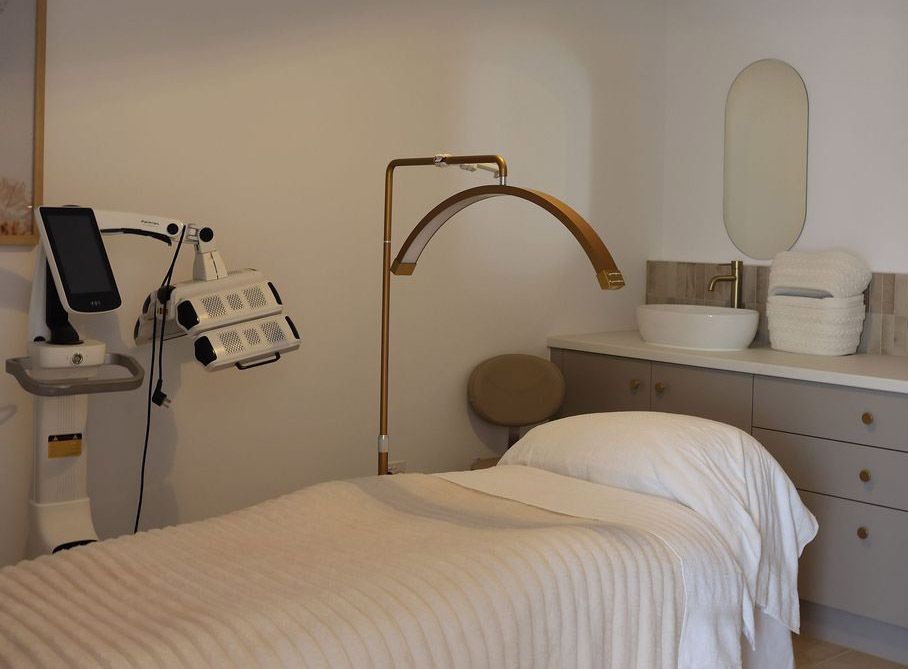 Medical treatment room with exam bed, ultrasound machine, and sink counter with supplies