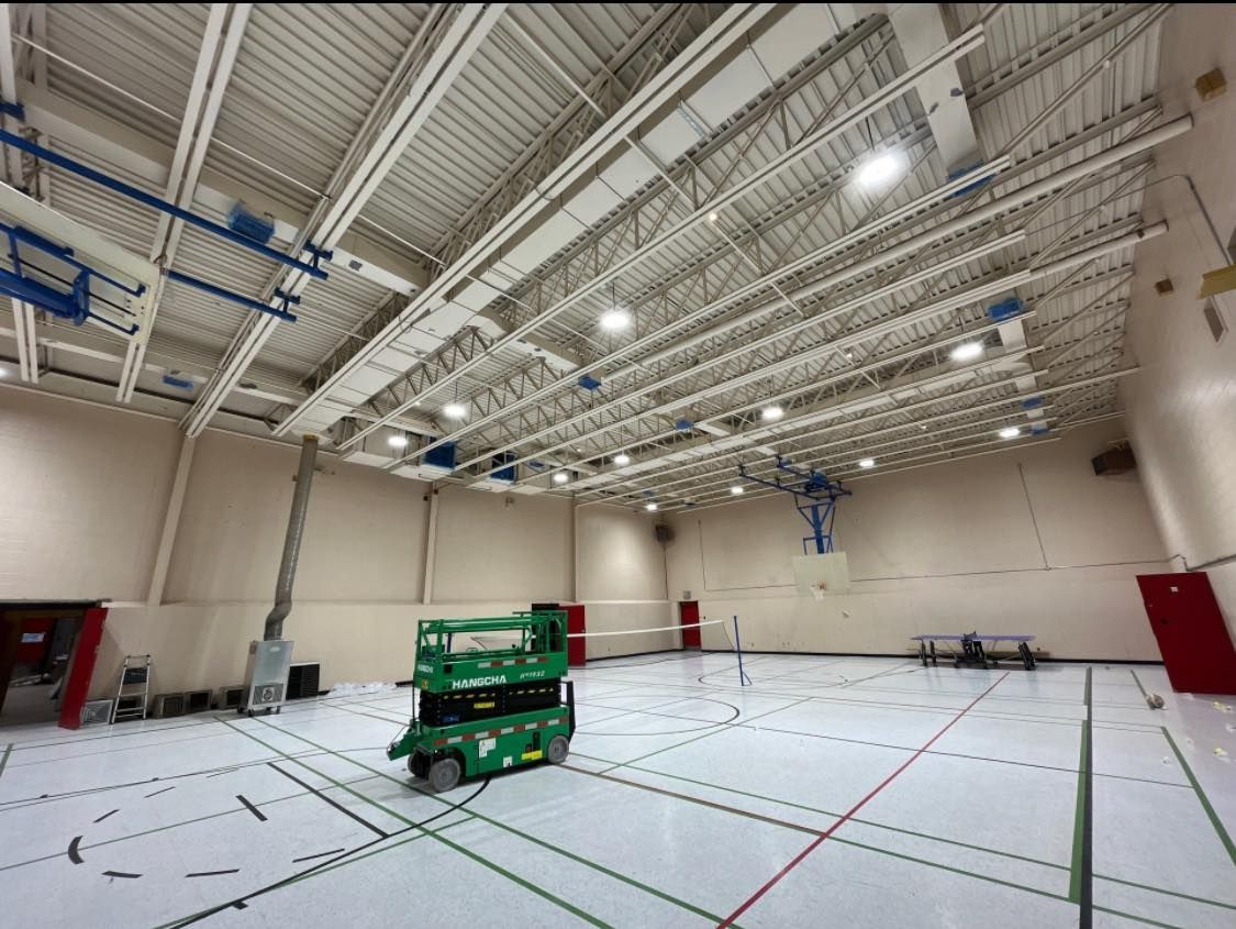 Une grue verte est assise au milieu d'un terrain de basket.