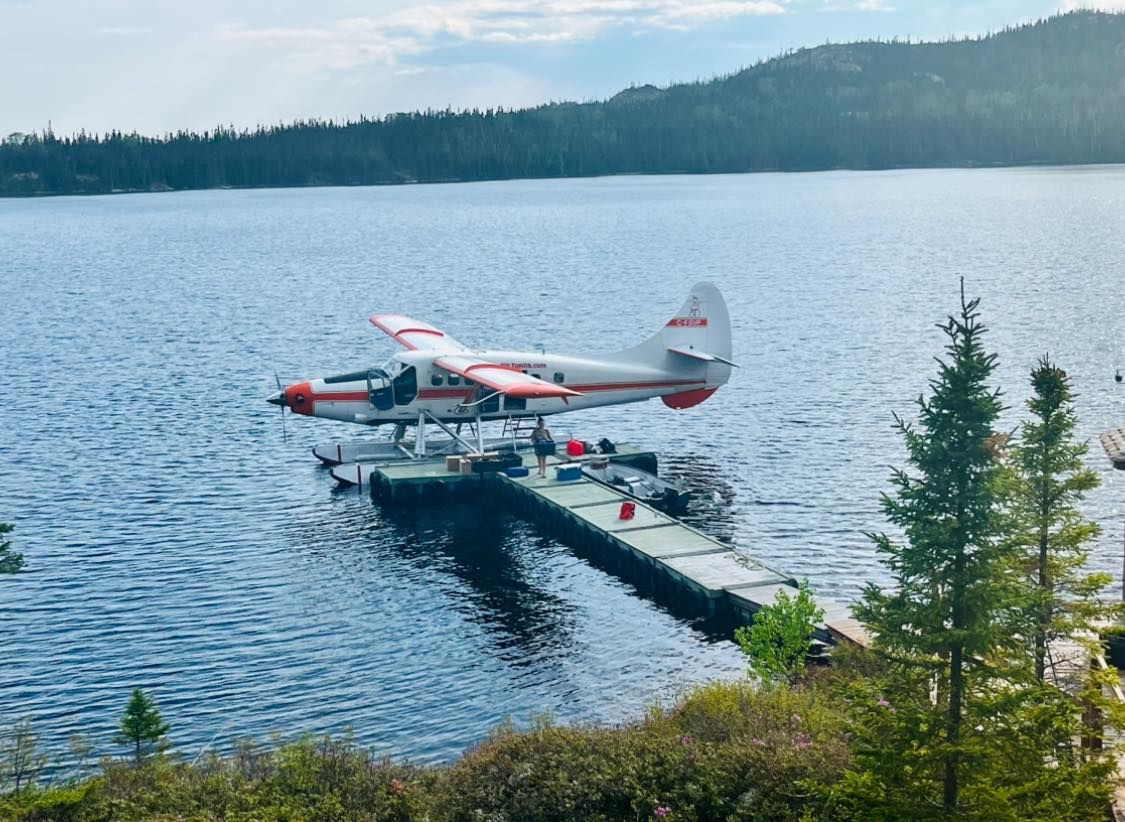 Un hydravion est assis sur un quai au milieu d'un lac.