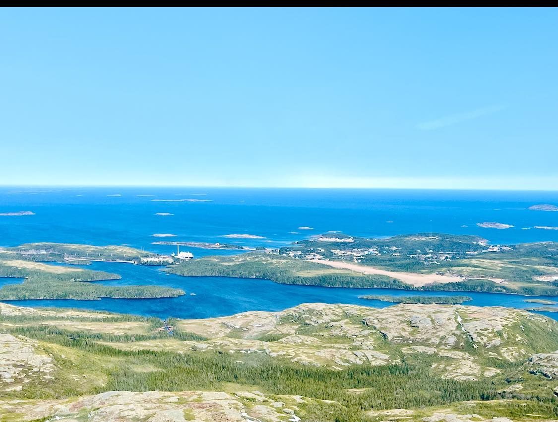 Une vue aérienne d'un lac entouré de montagnes et d'arbres.