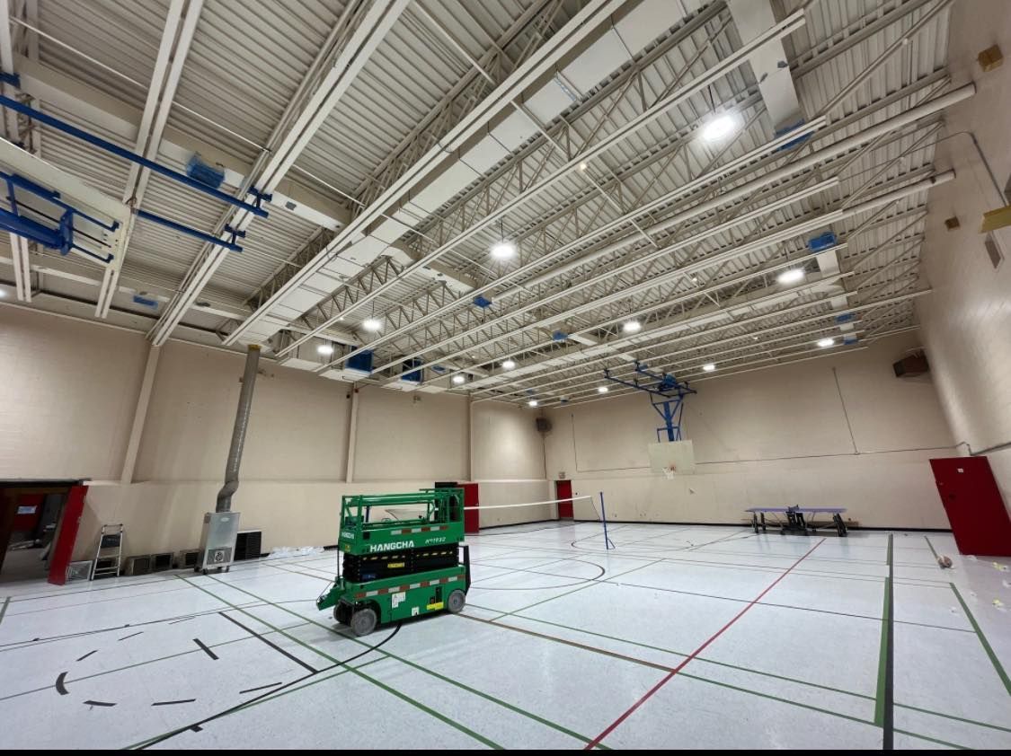 Une salle de sport vide avec un ascenseur vert au milieu