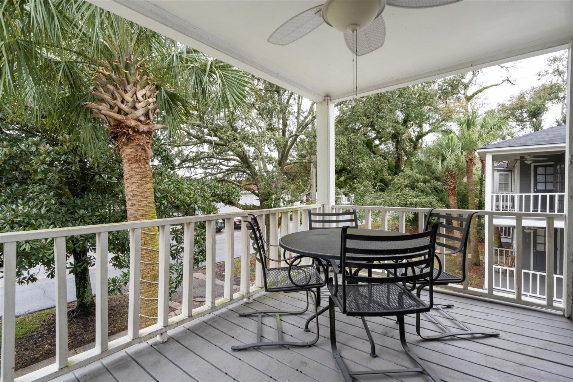A porch with a table and chairs and a ceiling fan