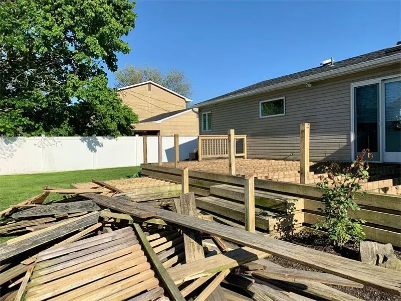 A wooden deck is being built in a backyard.