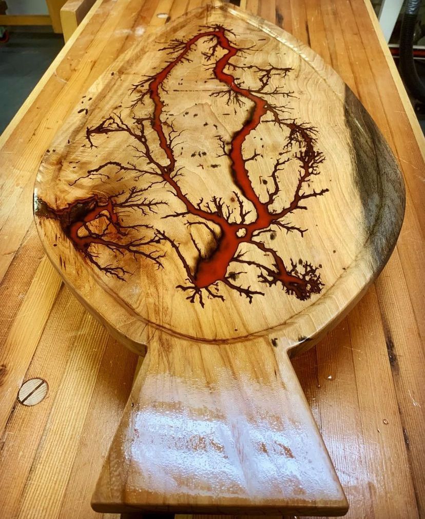 A wooden cutting board with a tree design on it