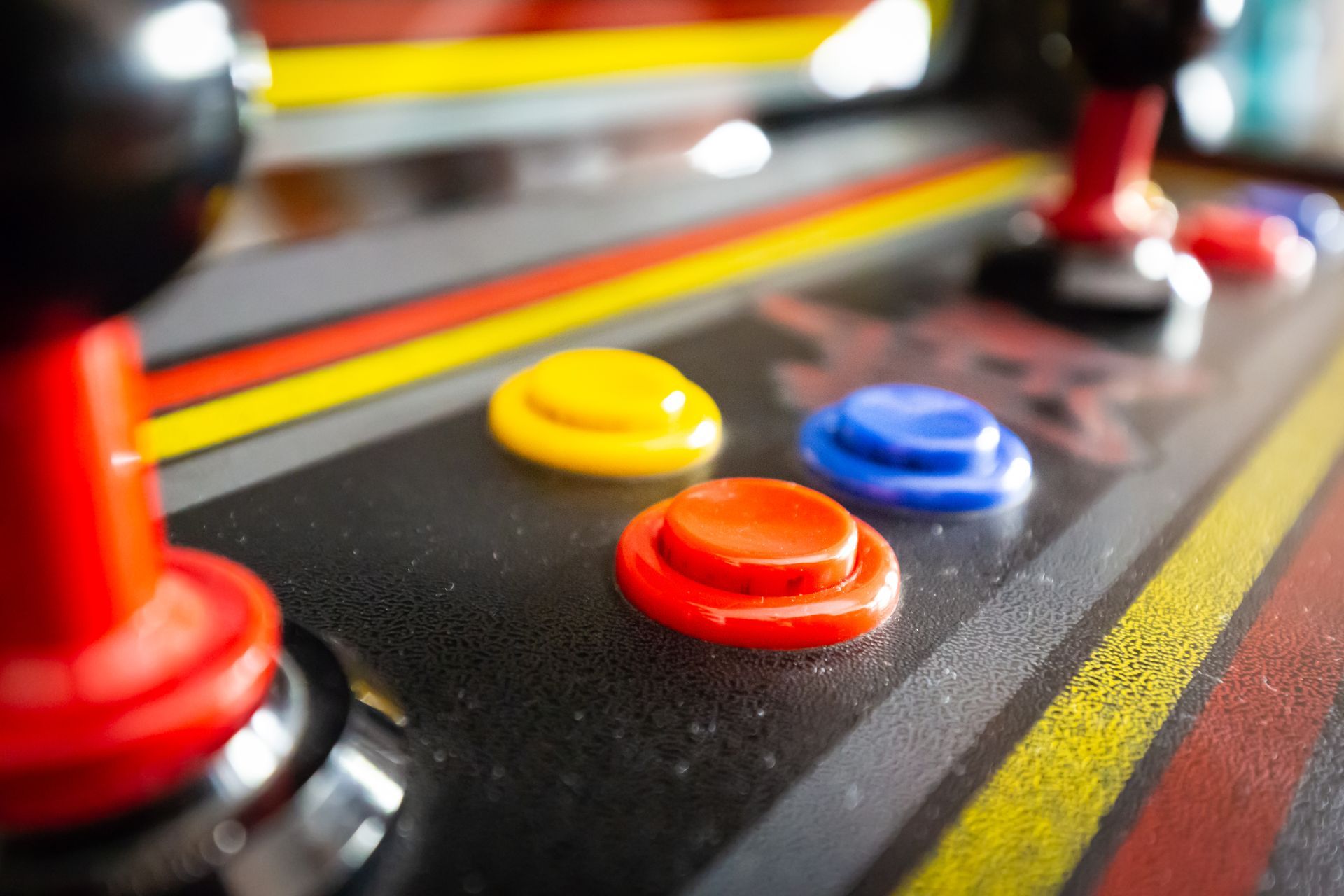 Close-up of colorful arcade game buttons and joystick on a control panel
