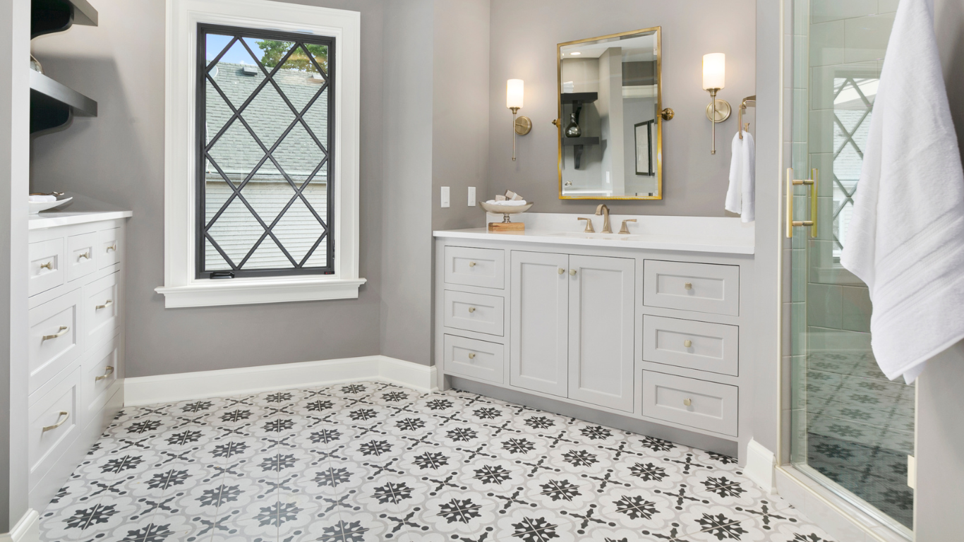 Bright white bathroom with patterned floor tile, double vanity, and glass shower