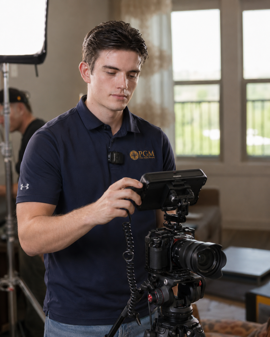 Man adjusting a camera rig on a tripod in a bright indoor room