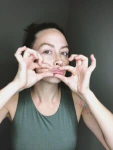 Esthetician performing facial massage on self