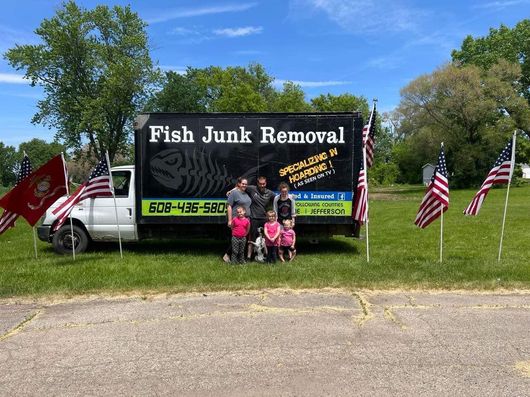 A family poses in front of a fish junk removal truck