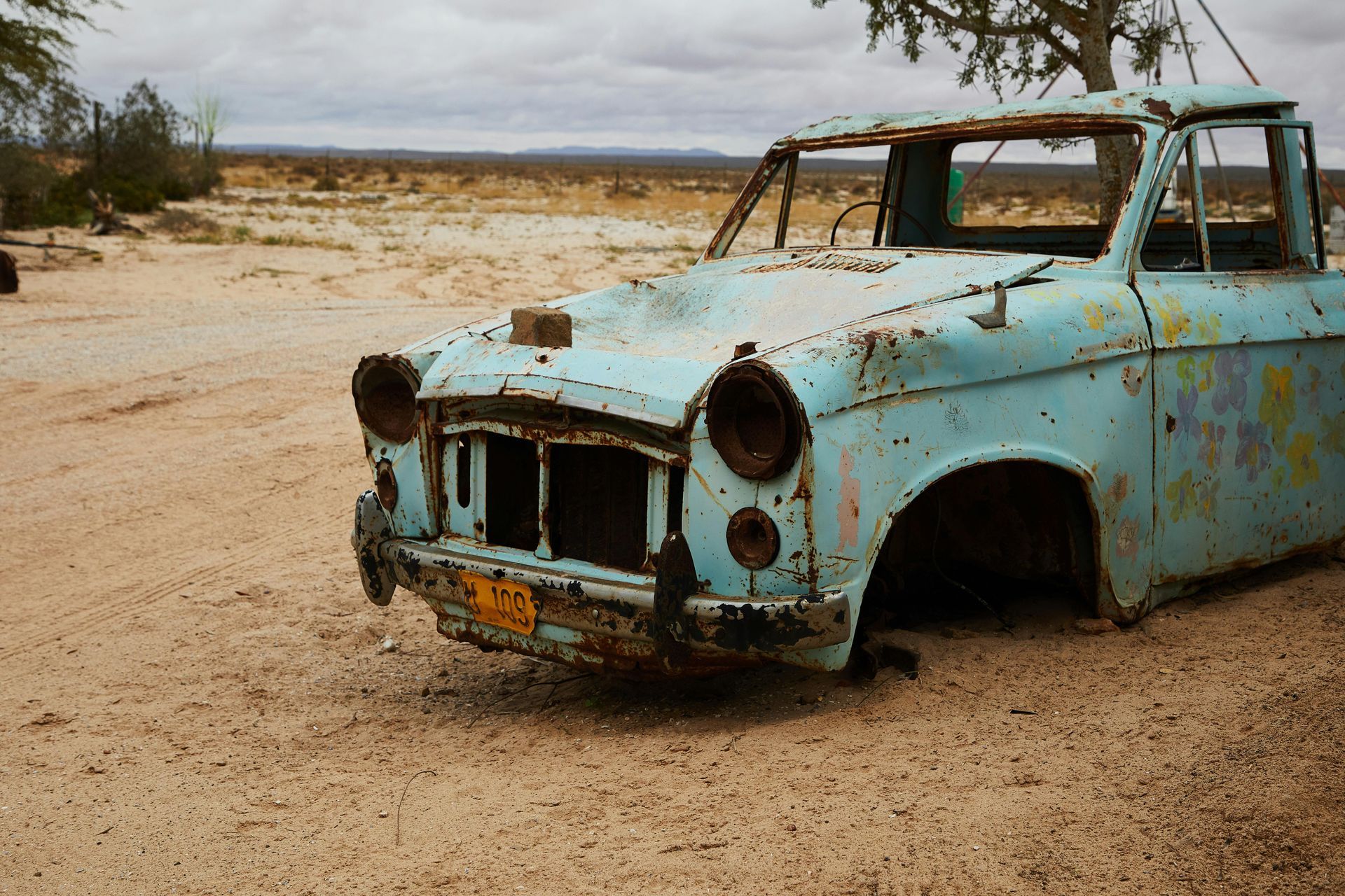 An old rusty blue car with a license plate that says t2