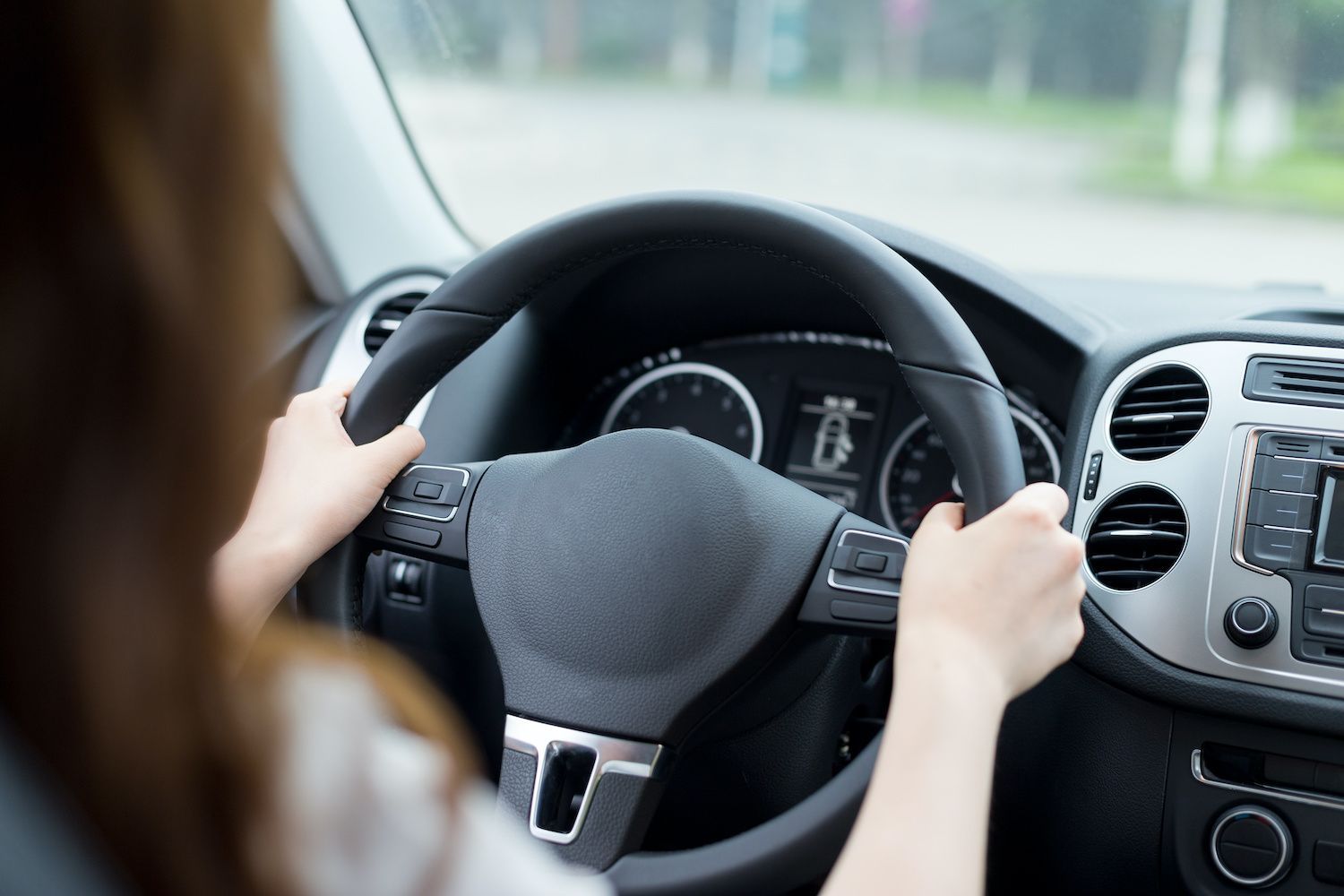 Person driving a car, hands on the steering wheel and dashboard visible | Dub's Garage