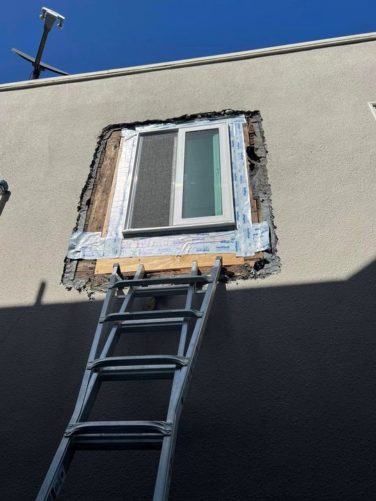 A ladder is sitting in front of a house under construction.