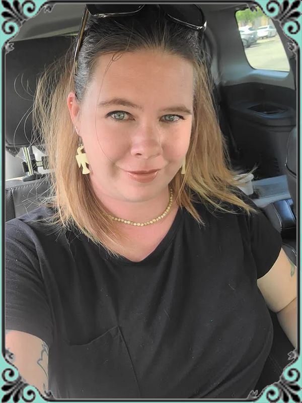 A woman is taking a selfie in the back seat of a car.