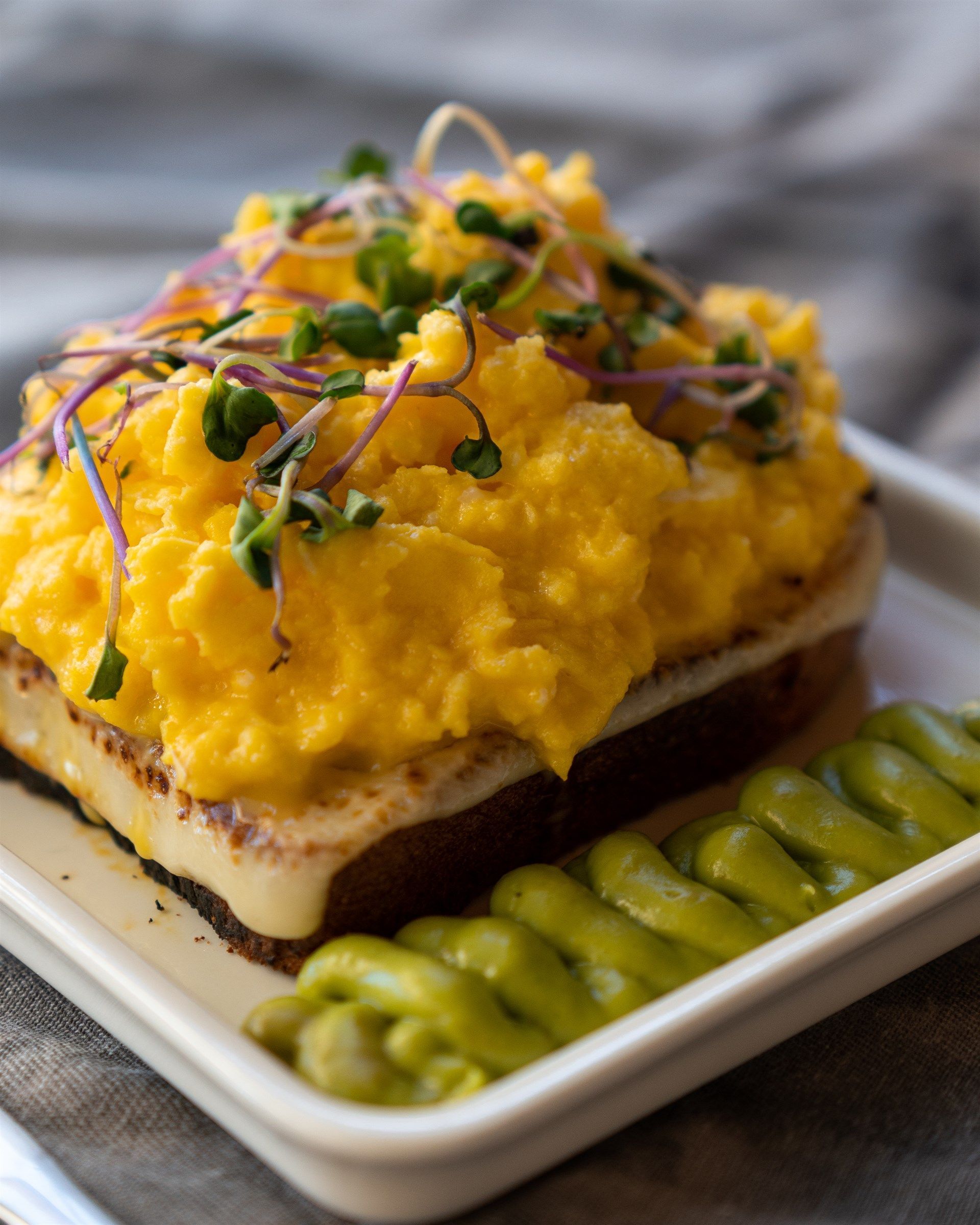 Un plato de comida con huevos revueltos y judías verdes.