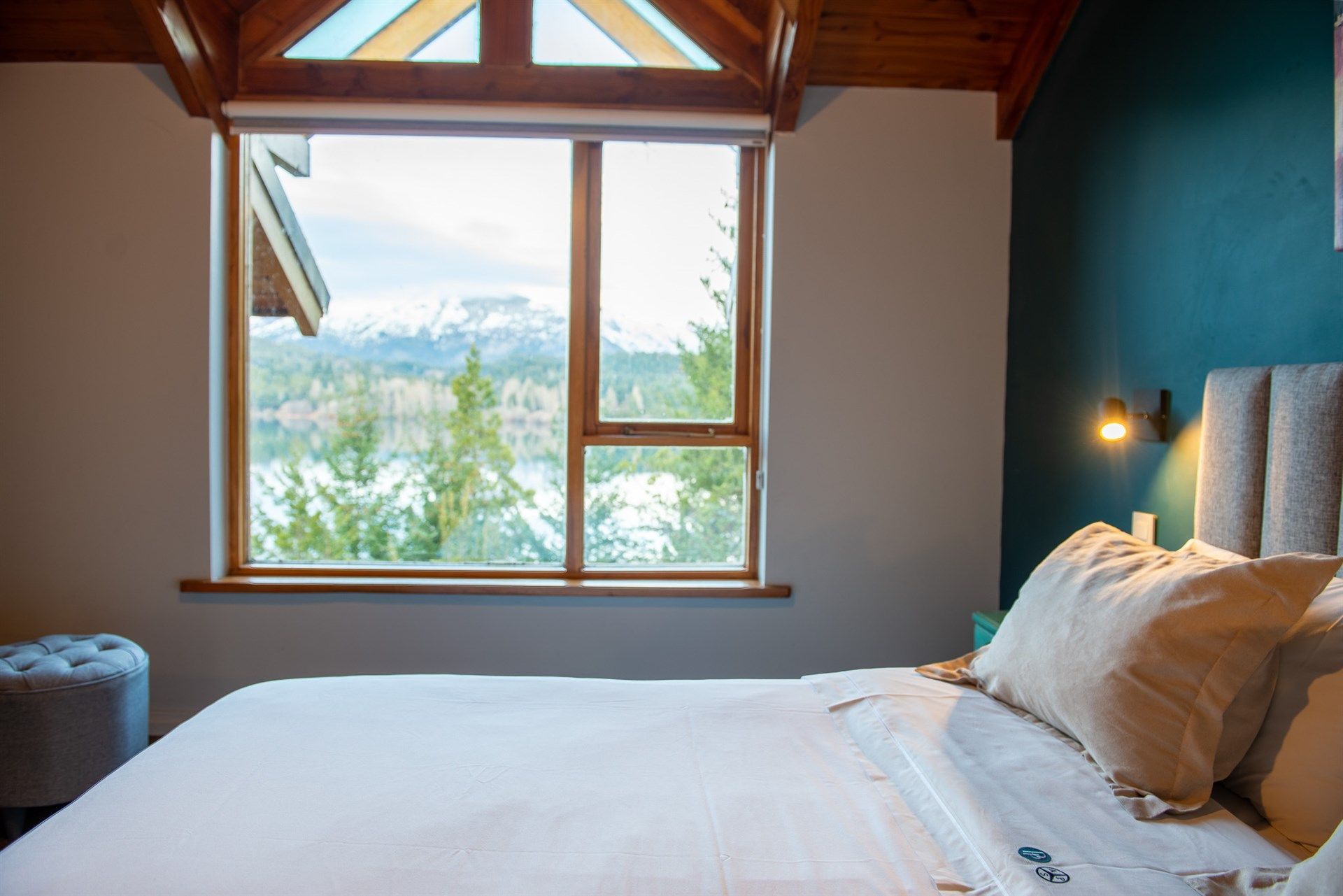 Un dormitorio con una cama y una ventana con vista a un lago.