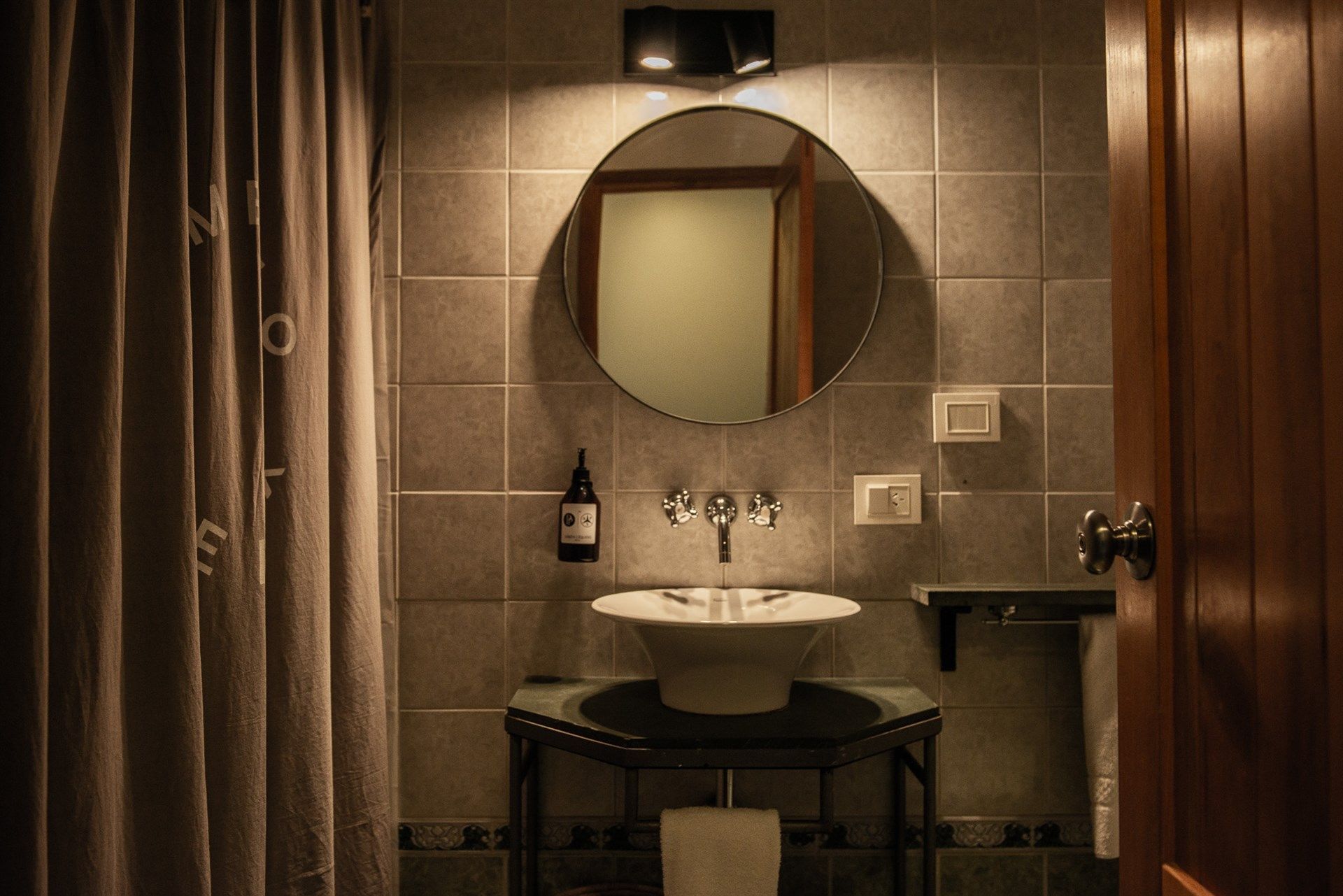 Un baño con lavabo, espejo y cortina de ducha.