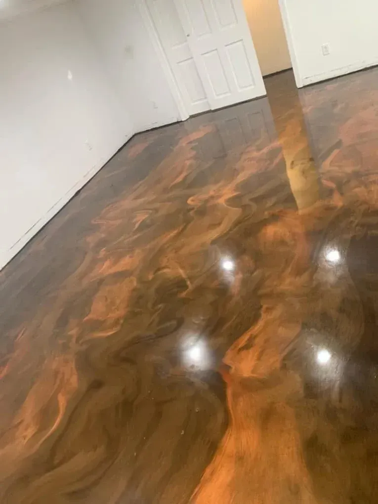 Polished dark wood floor in an empty room with white walls and a closed door