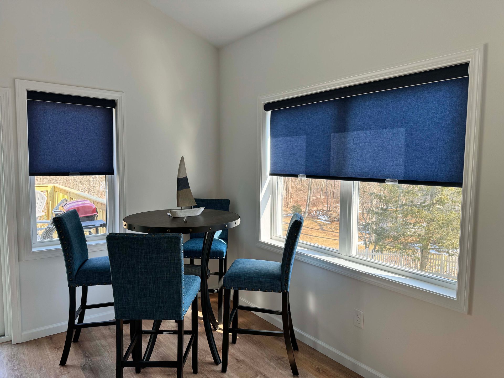A pair of roller blinds on a window in a living room.