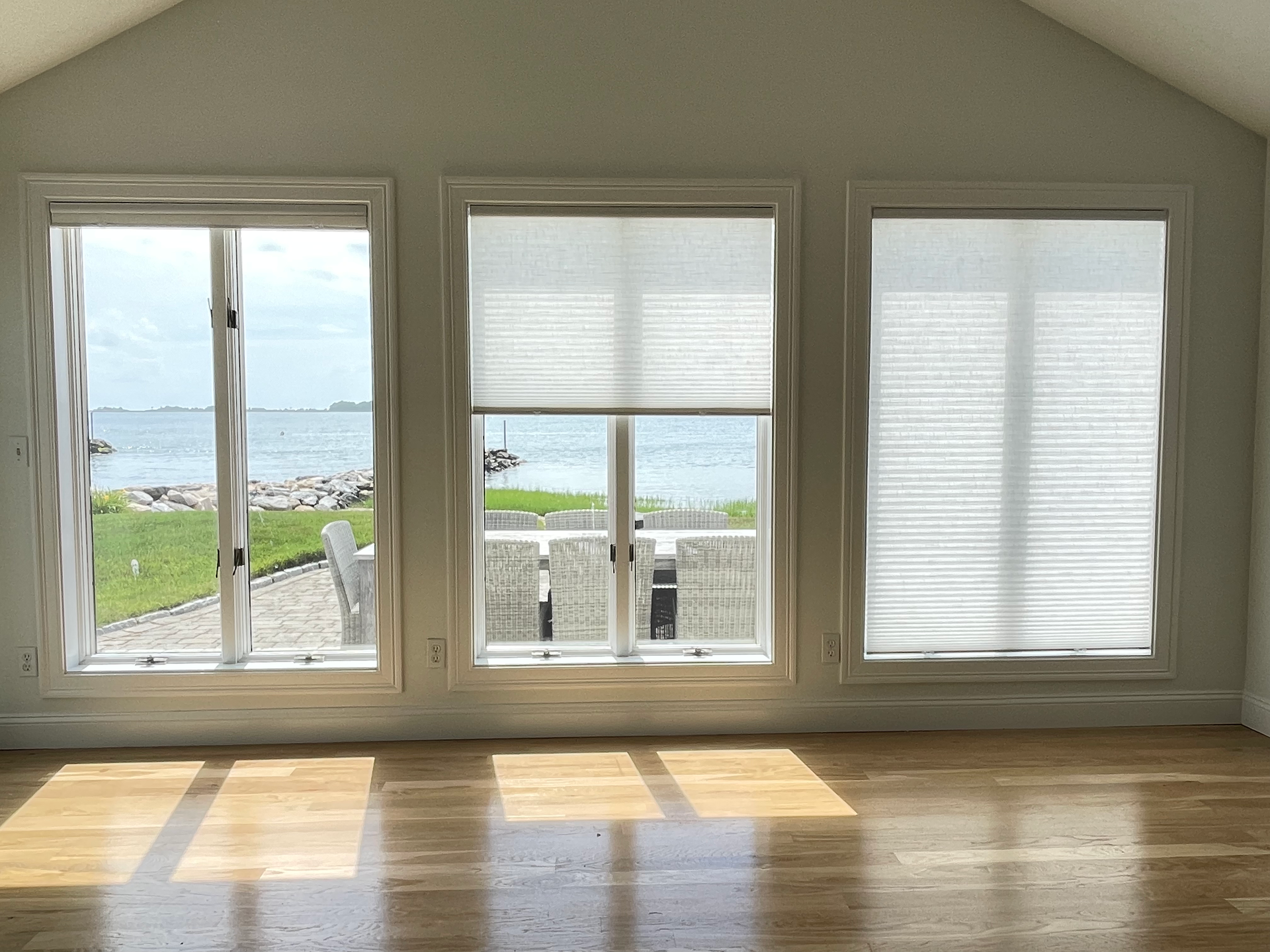A living room with a lot of windows and blinds.