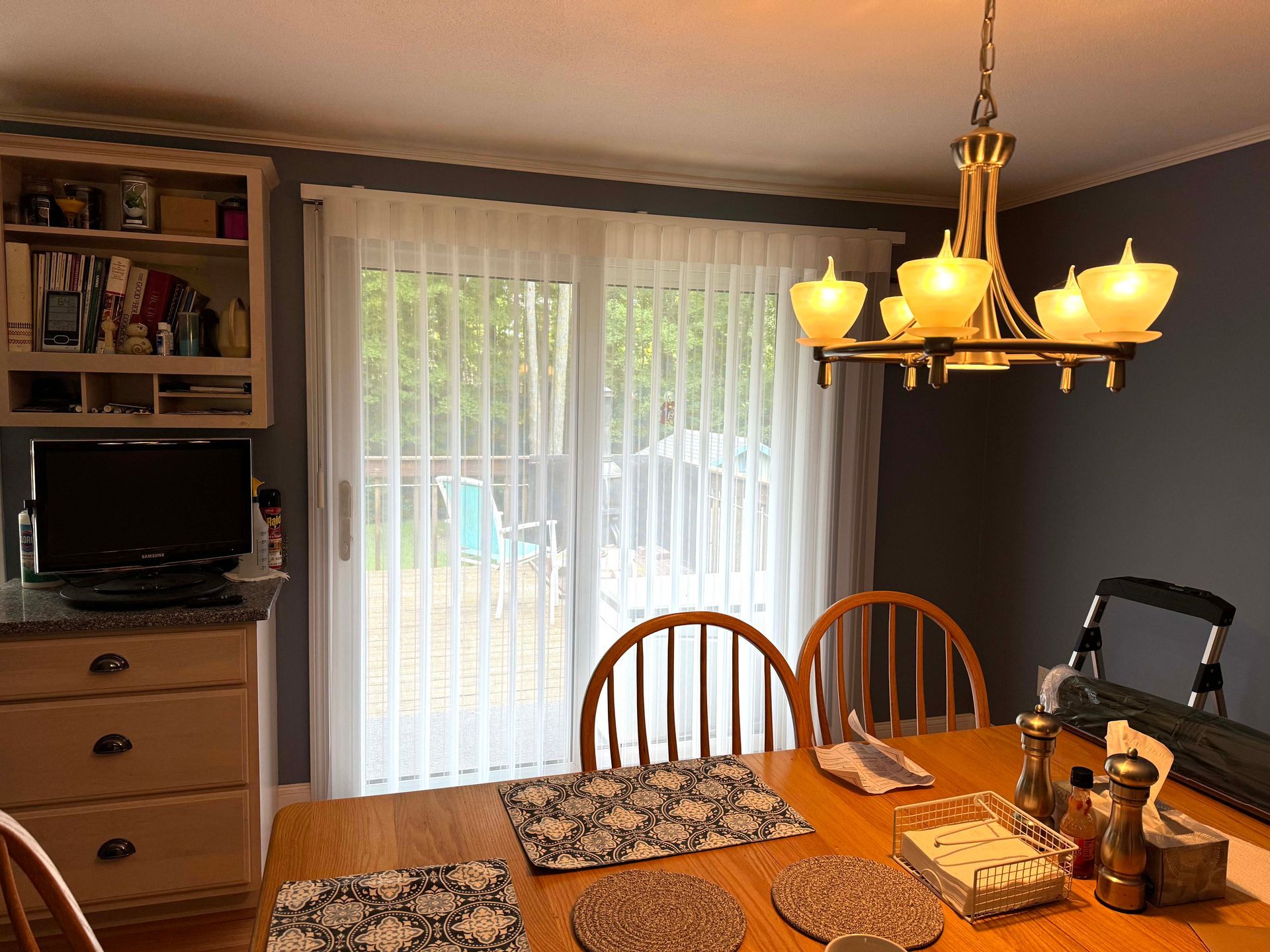 A room with a lot of windows and vertical blinds.