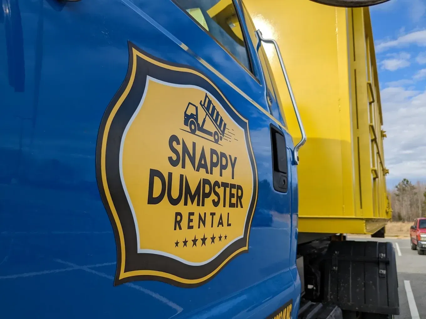 Blue and yellow Snappy Dumpster Rental truck side panel with logo