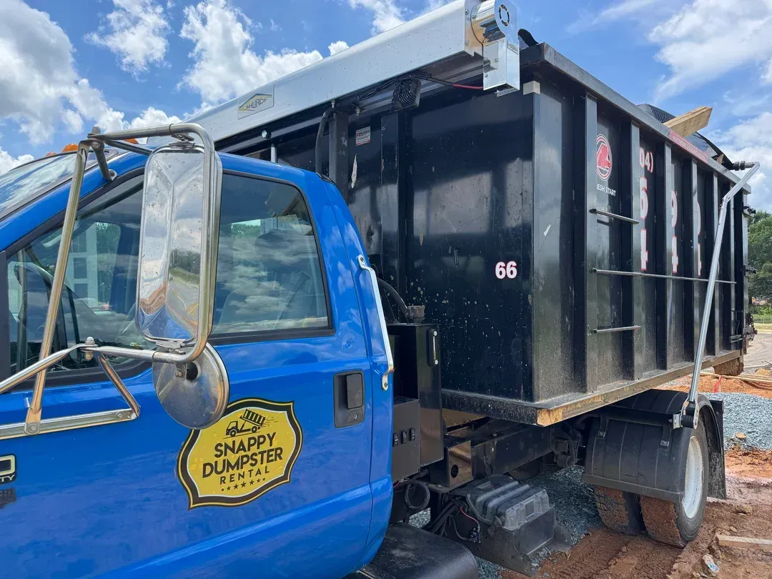 Blue truck with black dump bed parked outdoors in daylight