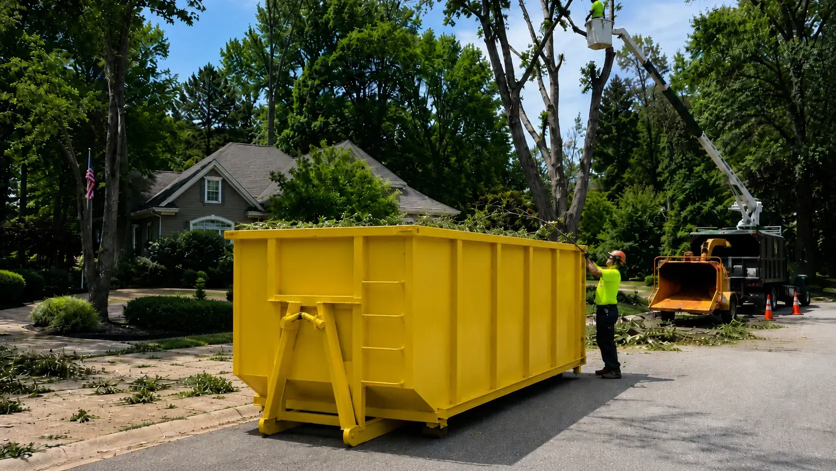 Yellow 30 yard dumpster at a tree removal job with arborists filling it