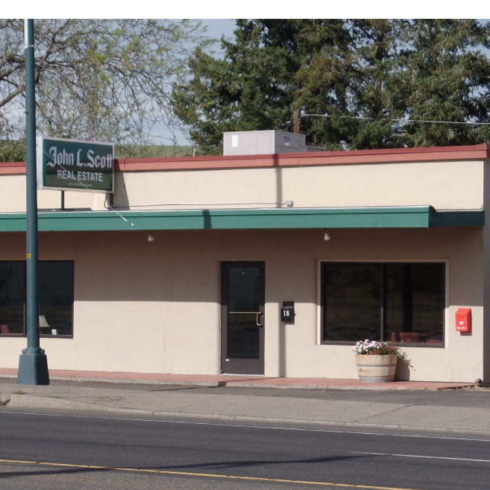 A building with a sign that says john l. sent real estate