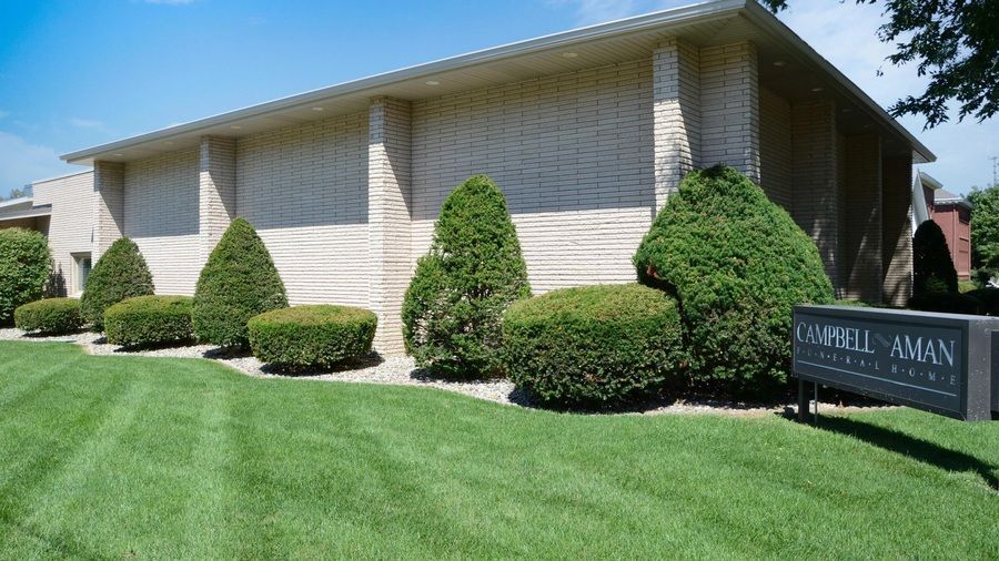 Exterior brick building and sign for Campbell-Aman Funeral Home.