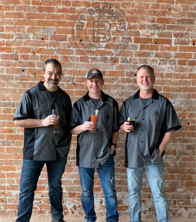 Jason, Jeff, and Scott standing in front of a brick wall with the BIT Logo