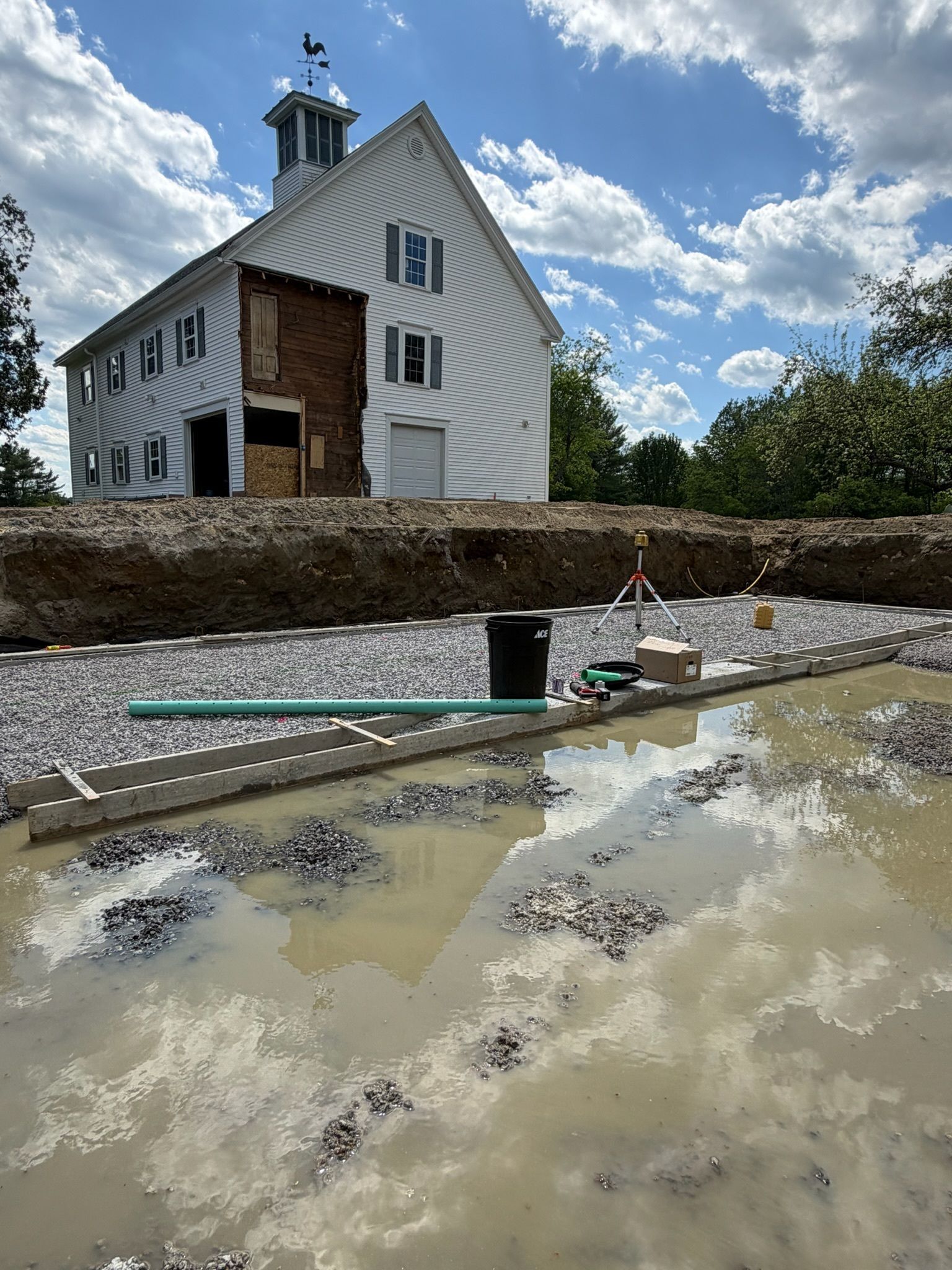 White house on a rocky shore with muddy water and a cloudy sky in Maine