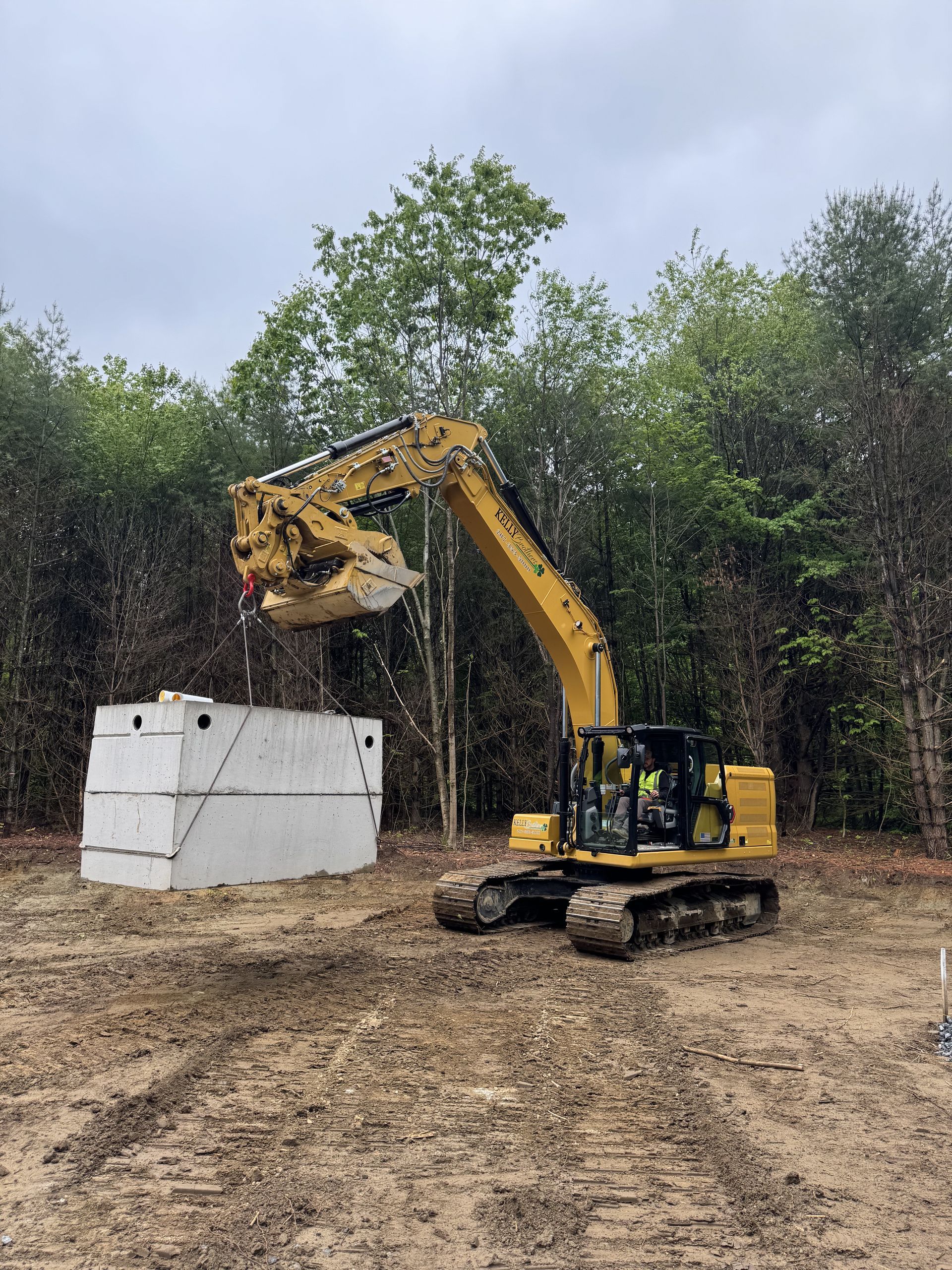 Overhead view of an excavator clearing dirt in a tan construction site in Lisbon Maine