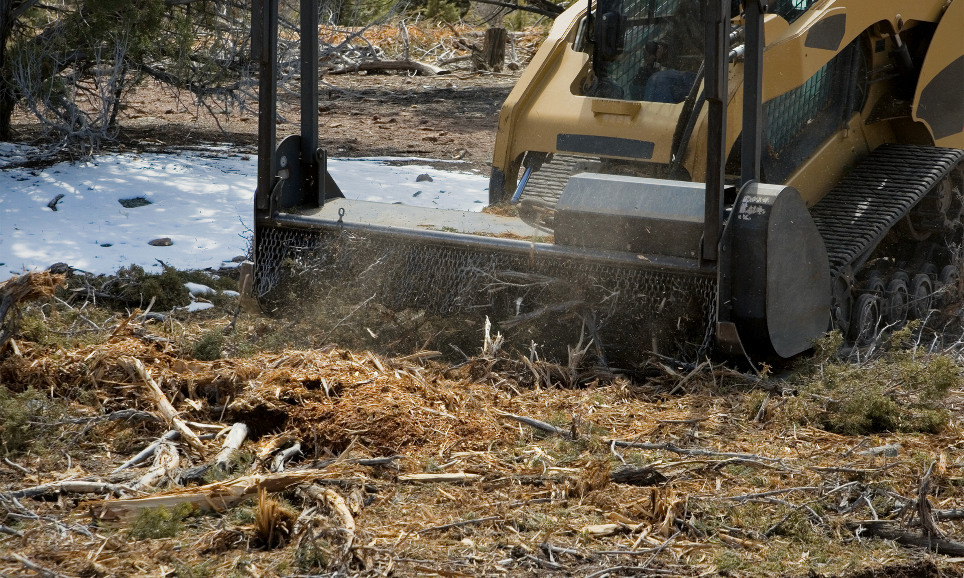 Overhead view of an excavator clearing dirt in a tan construction site