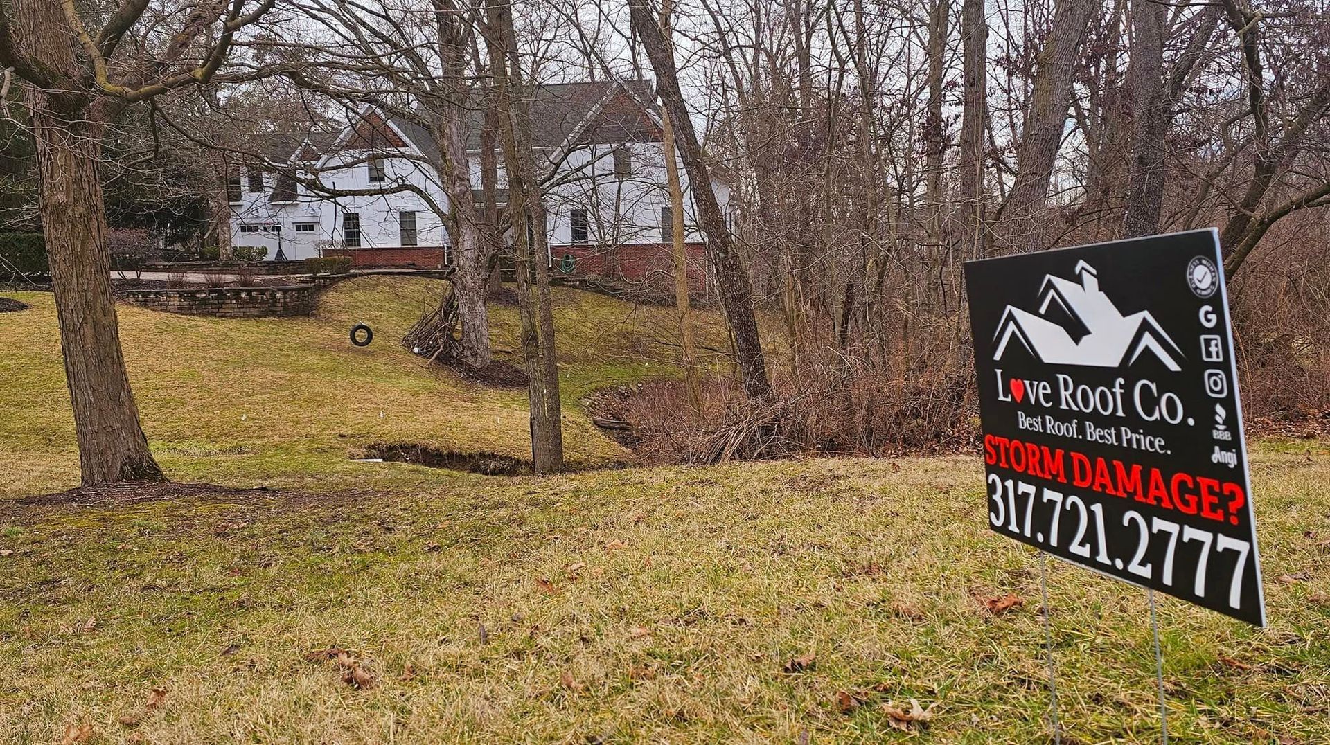 Yard sign in a leaf-covered field advertising Love Roof Co.