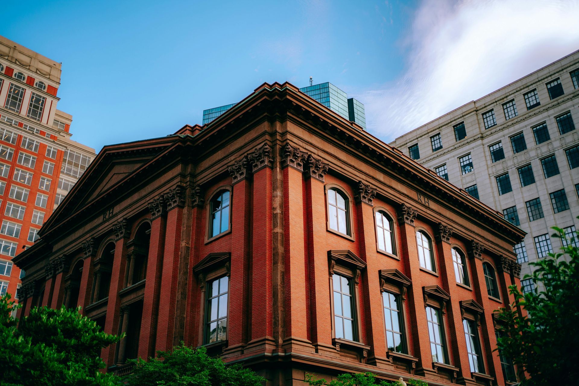 Red brick corner building with tall windows against a blue sky