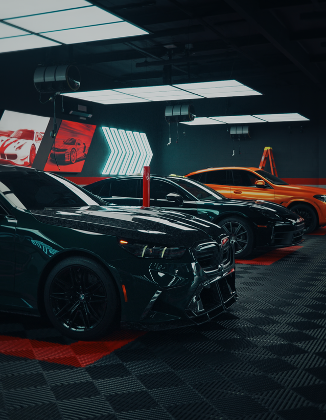 Black cars in a red-lit showroom with digital display walls and arrow graphics