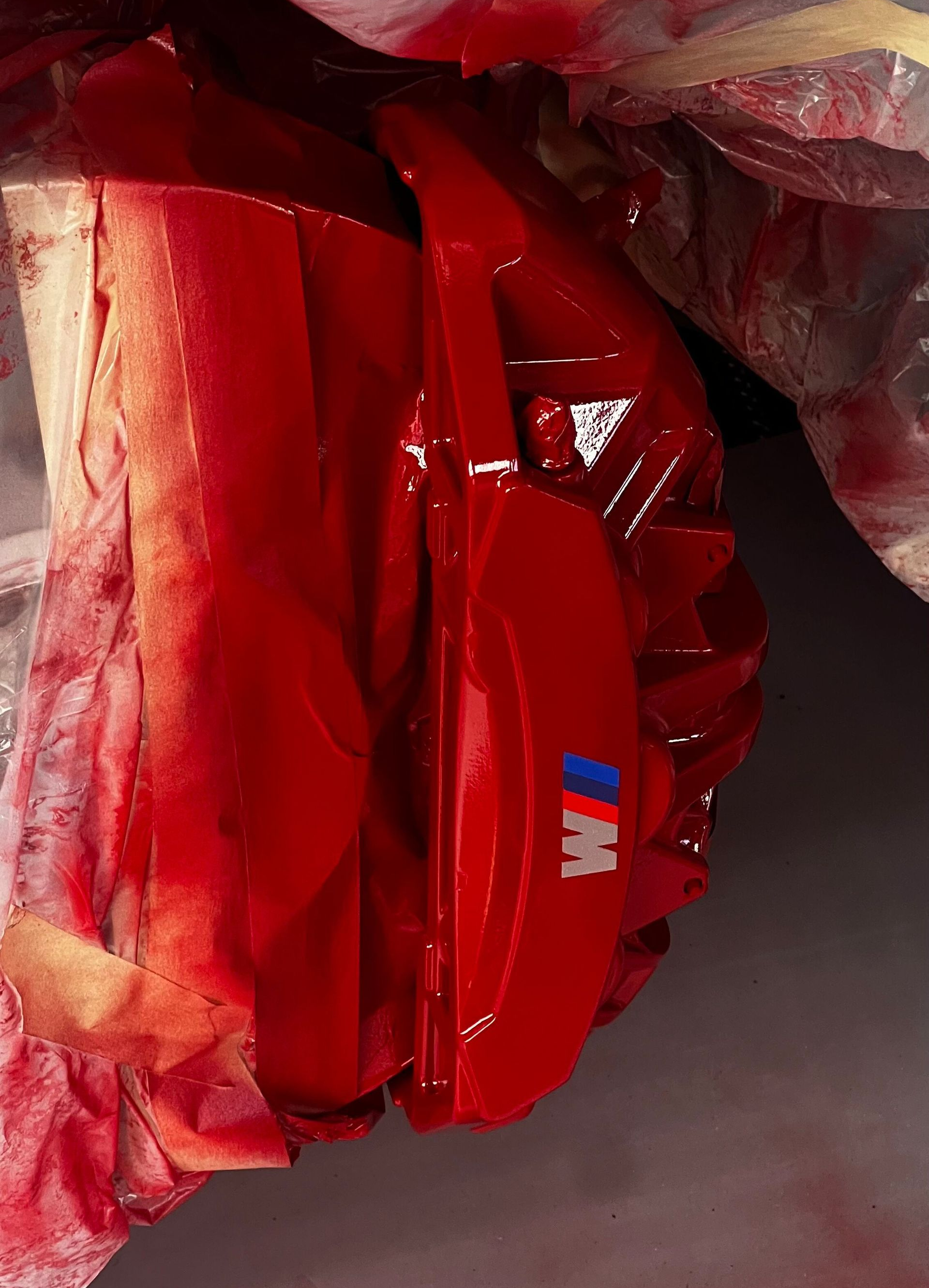 Red insulated lunch bag with blue accents tucked in a gray plastic-lined container