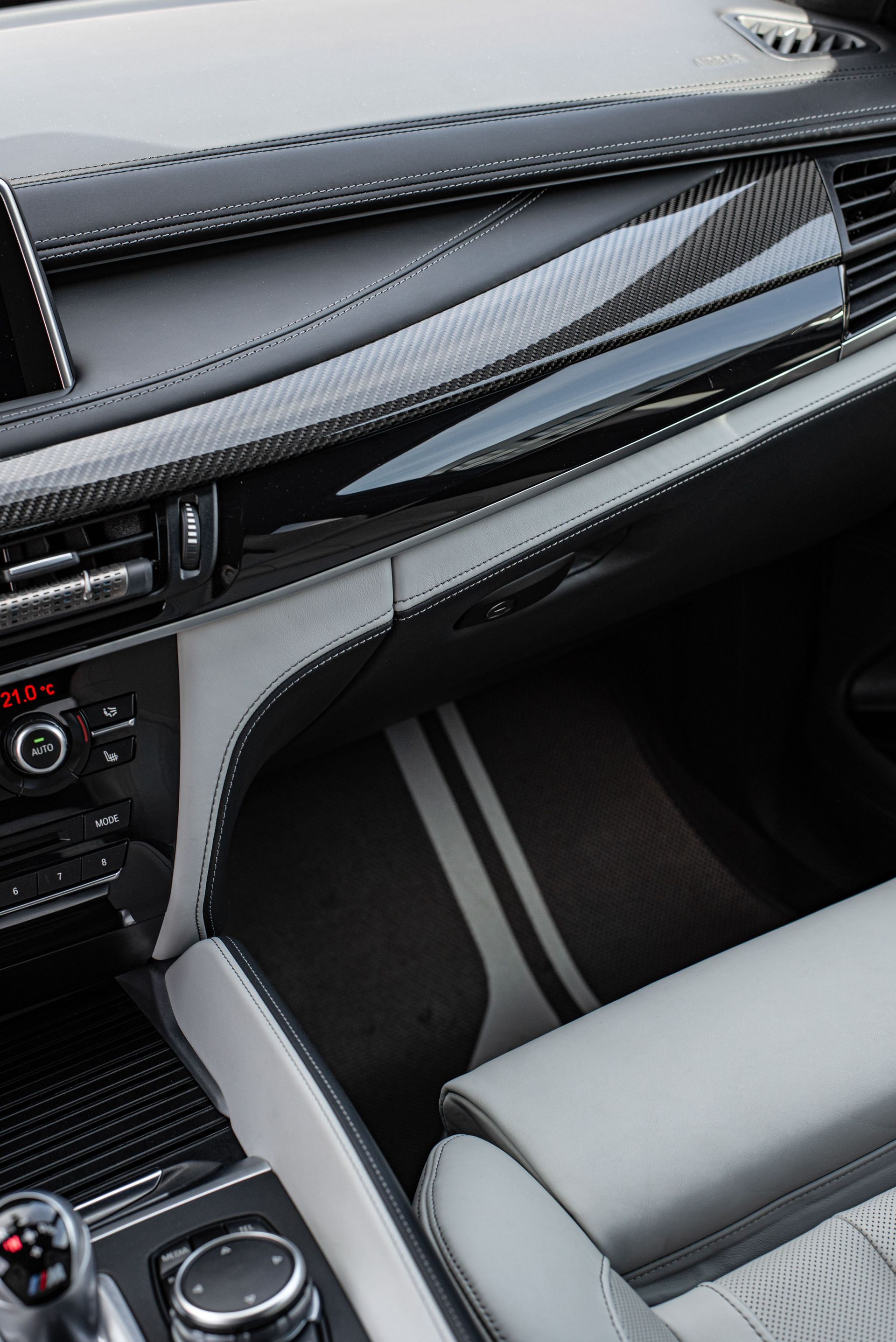 Car interior with black dashboard, silver trim, and a light gray front seat.